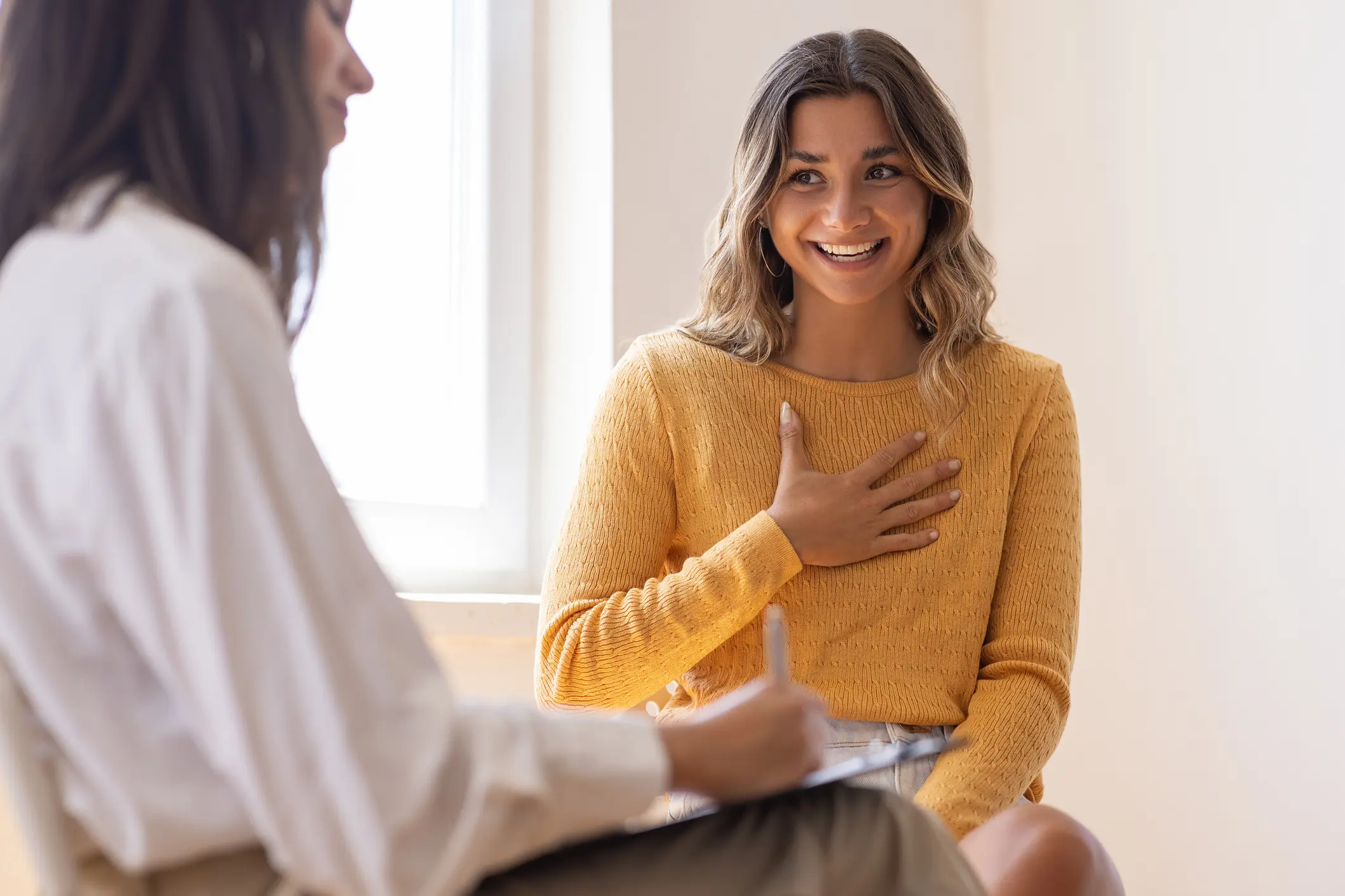 Two women talking in a bright room