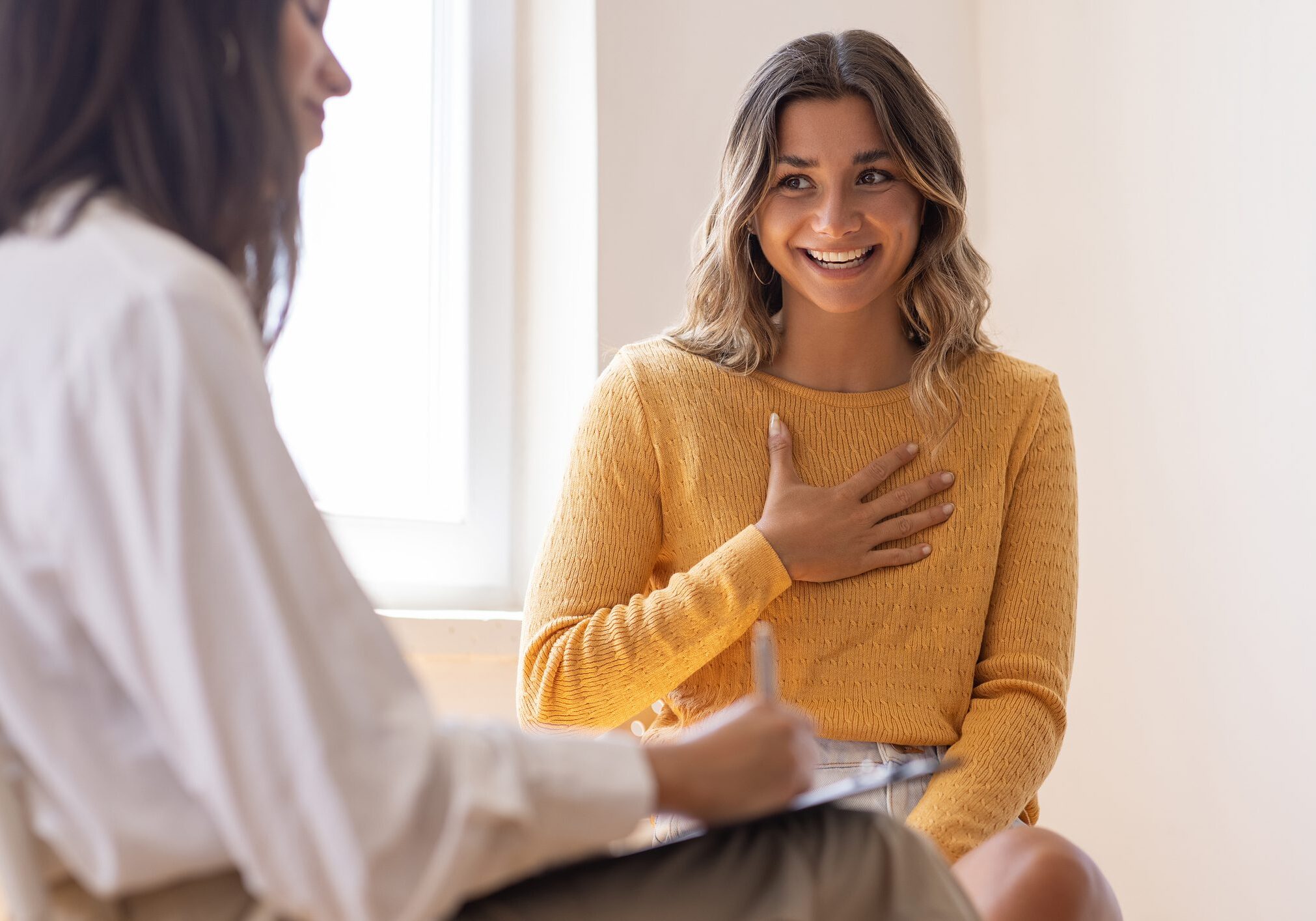 Two women talking in a bright room